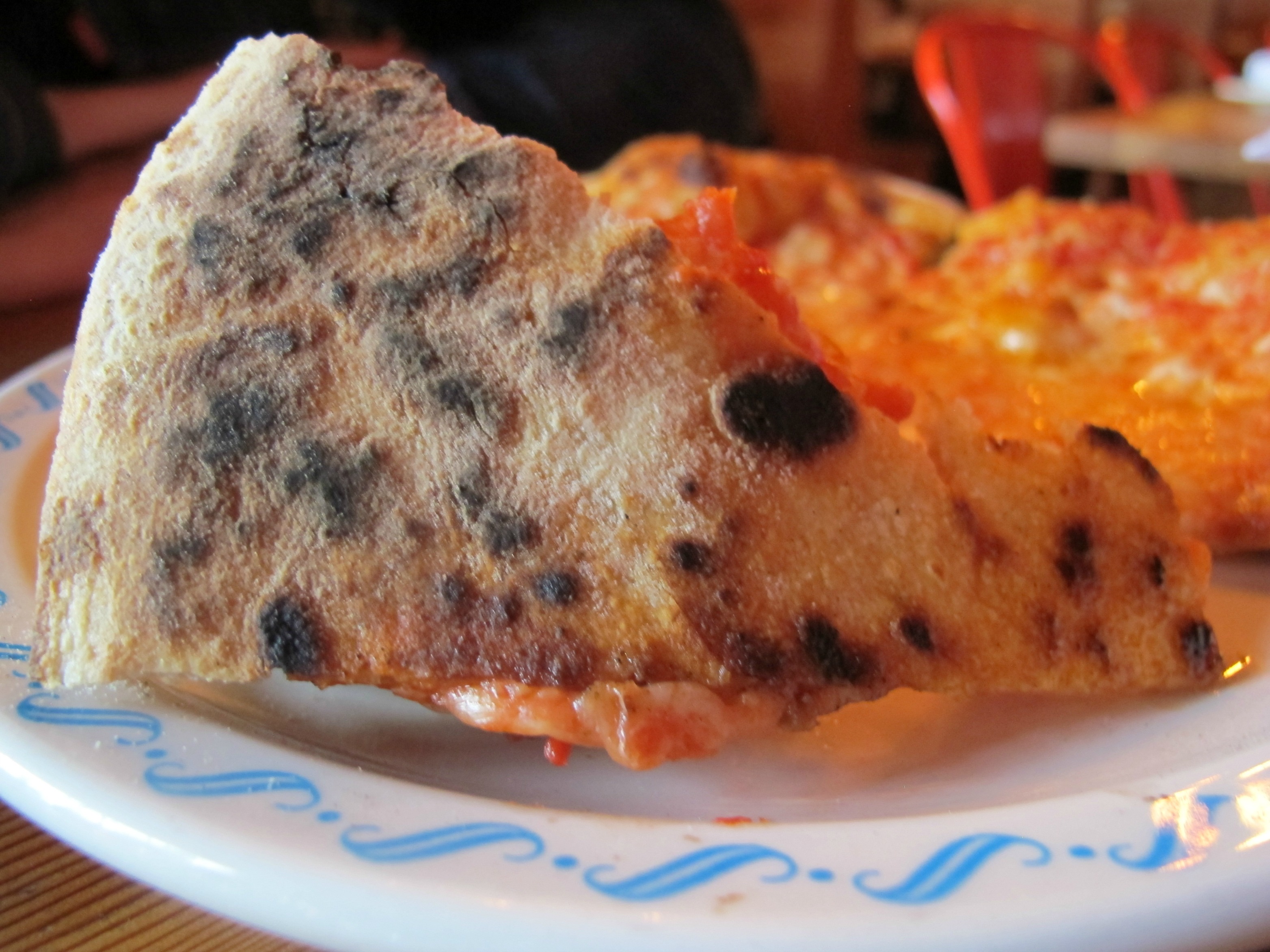 Charred crust on a slice of pizza from Lovely's Fifty Fifty in Portland, Oregon \ vegetarianPDX